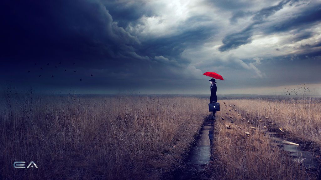 Thundercloud sky over a field of dead grass through which runs a track filled with water. A person stands on the track with a briefcase, black coat, black hat, and red umbrella