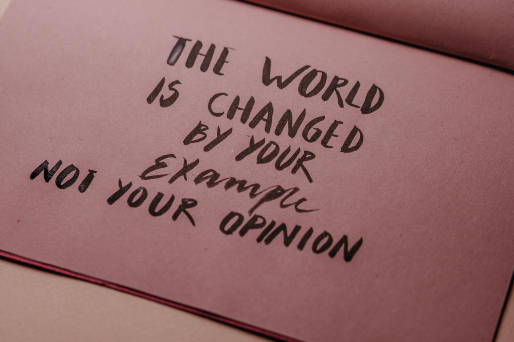 close-up of handwritten note that says 'The world is changed by your example not your opinion'
