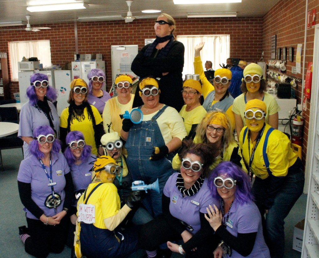 Group of 17 white females dressed as Minions with one dressed as 'Gru'